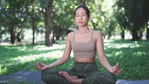 Woman Meditating in Peaceful Green Park Setting