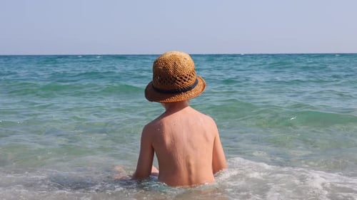 kid playing on beach in sea water swimming,splashing,running or floating on waves