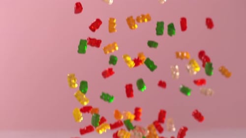 Colorful Gummy Bears Falling onto White Surface
