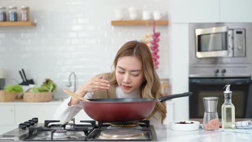 Woman Cooking Delicious Meal in Kitchen