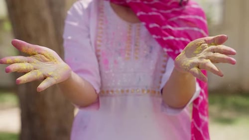 Woman Clapping Hands with Yellow Holi Powder