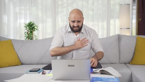 Heimbüroangestellter Mann hat einen Herzinfarkt.