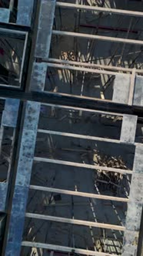 Vertical Aerial View Workers Moving Across Concrete Framework with Balanced Composition