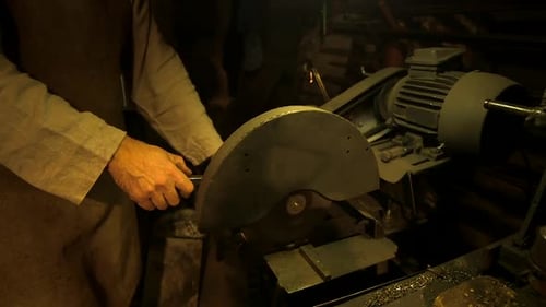 Der Schmied schneidet in der Werkstatt Metallstangen mit einem Eisenschneider.