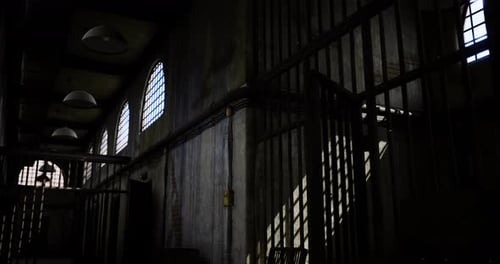 Historic Prison Interior Showcasing Barred Windows and Dramatic Lighting