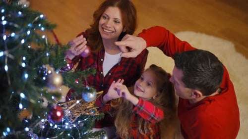 Happy Family Decorates Christmas Tree Together