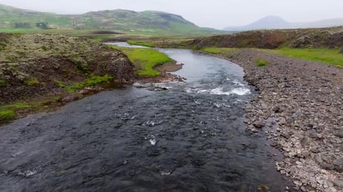 Drone Aerial of Iceland River Flowing Through Rugged Landscape