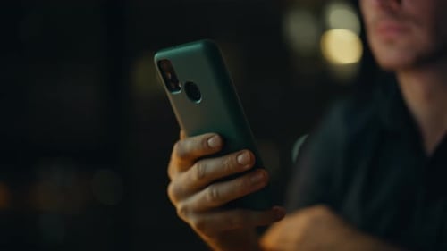 User Hand Touching Smartphone at Dark Apartment Closeup Happy Student Browsing