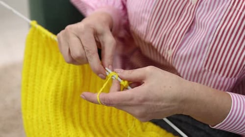 Woman Knitting a Bright Yellow Wool Scarf