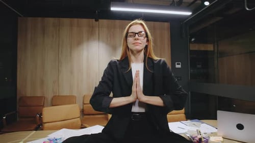 Woman Meditating in Office at Desk
