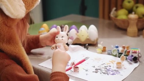 Child Painting Easter Bunny at Table Indoors
