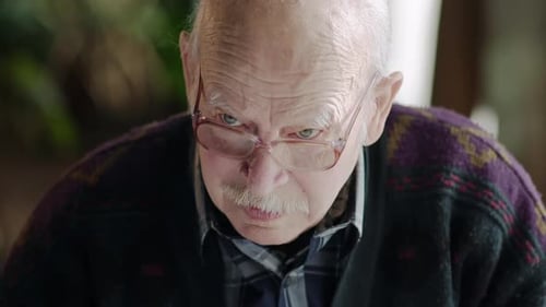 Elderly Man in Coffee Shop Sitting Alone at a Table