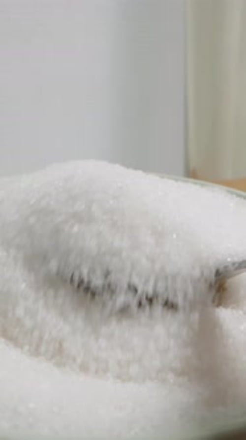 Vertical video. I Scoop Sugar with A Spoon And Pour It into A Glass. POV, Slow Motion.