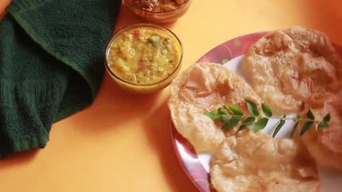 rotation Chole Bhature or Chick pea curry and Fried Puri served in terracotta crockery over yellow b