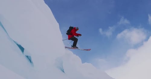 Skifahrer springt in Zeitlupe von einem Gesims, Skiurlaub im Hinterland