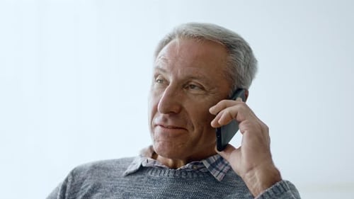 Senior Man Enjoying Conversation at Home in Cozy Living Space
