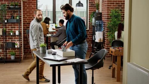 Frustrated Jobless Man Getting Fired From Work and Packing Belongings in Box