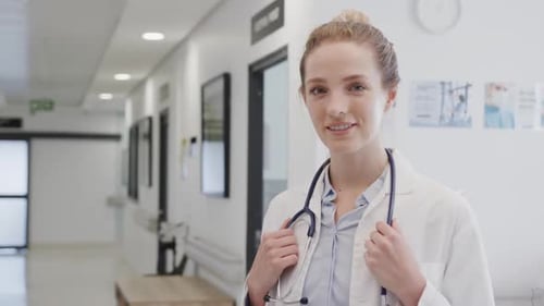 Portrait of happy female doctor with stethoscope smiling in hospital, in slow motion, copy space