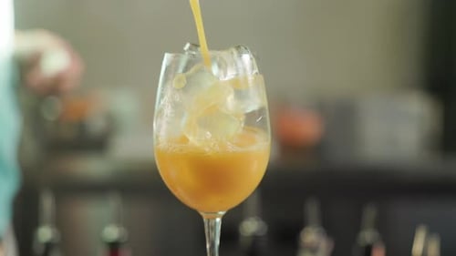 Refreshing Amber Drink Poured into Glass of Ice