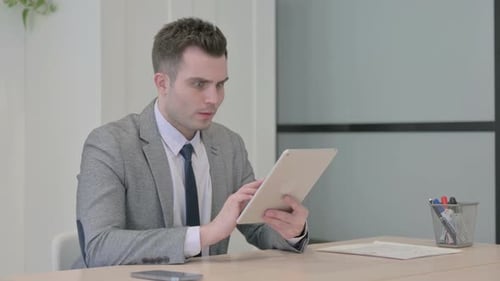 Man Reacts to Tablet News in Office