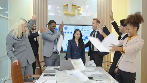 Excited Team Celebrating Success in Modern Boardroom