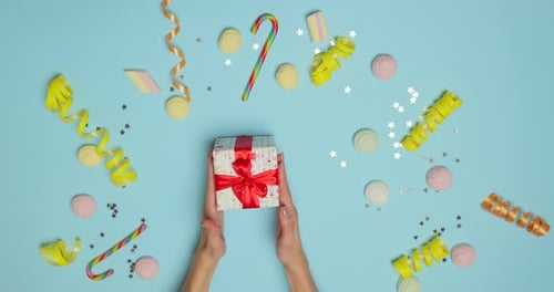 Top View Hands Put Christmas Presents at on Blue Background From Above