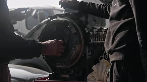 Tightening The Flywheel Gear Of The Old Car Engine In The Repair Shop