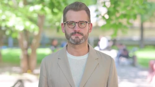 Portrait of Serious Businessman Outdoor in Park