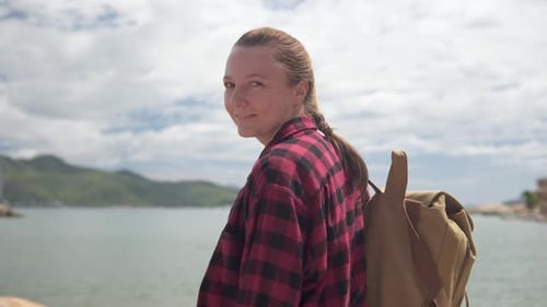 Woman With Backpacking on Beach Turns to Smile