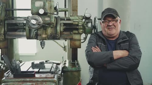 Man In Front of Large Machine in Factory