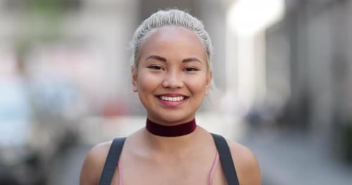 Smiling woman with blond hair on city street