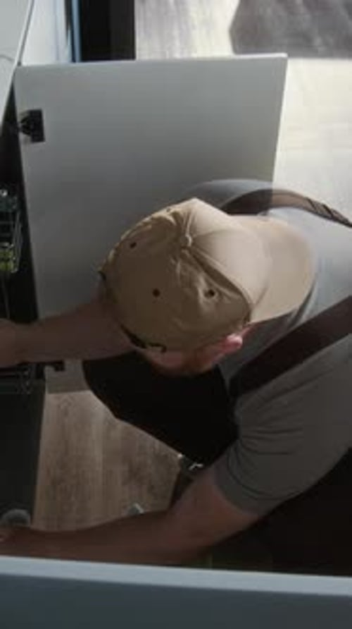 Plumber Inspecting Piping under Sink