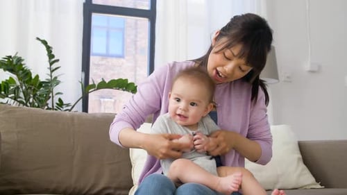 Familien- und Mutterschaftskonzept - Glücklich lächelnde junge Mutter mit kleinem Baby