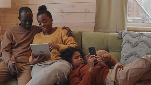 Family Relaxing Together on Couch with Technology