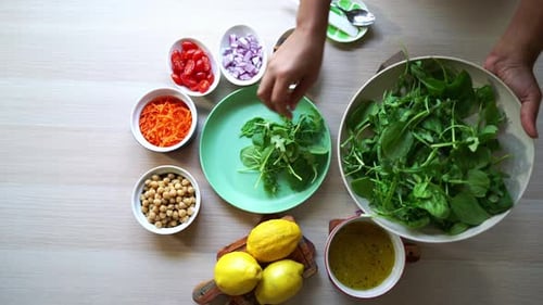 Adding spinach leaves to plate aerial view of all ingredients on the table