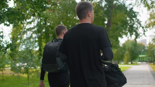Friends Strolling Through Park People Casually Walking Along Treelined Pathway Two Companions