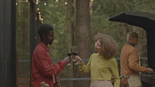 Couple Toasting with Wine and having Talk on Outdoor party in Woods