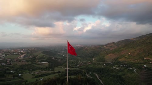 Aerial View of Flag Waving over City at Sunrise