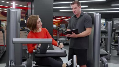 Woman Training at Gym with Personal Trainer