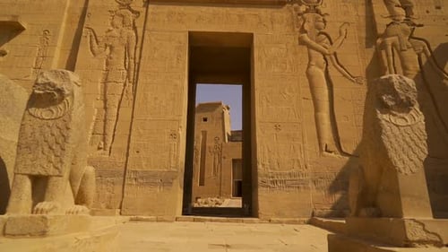 A young woman visiting the beautiful Temple of Philae, a Greco-Roman construction seen from the Nile