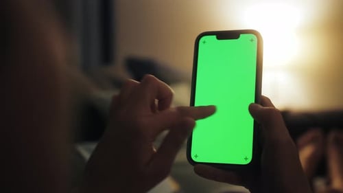 Back View of Woman Holding Smartphone with Green Screen Watching Content Social Media