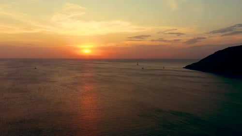Orange sunset over the sea. The sun is setting over the horizon. Evening view of the mountains and s