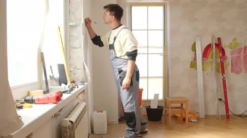 Construction Worker Taking Measures on Wall in Apartment Renovation