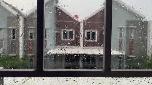 Raindrops on Window with Suburban Houses in Background