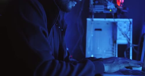 Um hacker masculino está usando um computador para hackear dados e exigir resgate das vítimas.