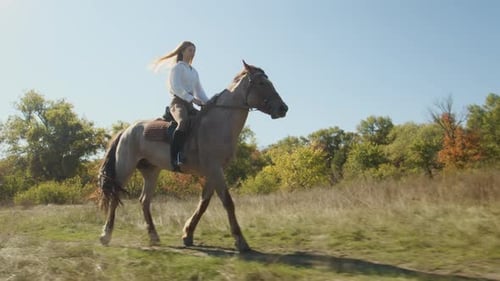 Jóquei feminina loira caucasiana curtindo andar a cavalo