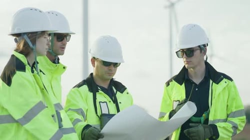 Engineers Reviewing Plans at Wind Turbine Farm