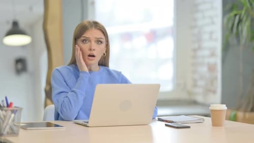 Shocked Woman Reacts to Laptop in Office