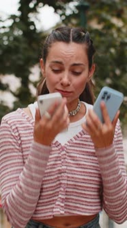 Expressive young woman talking on phone in city