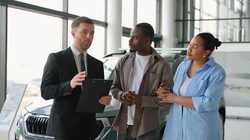 Car Salesman Explaining Vehicle to a Couple